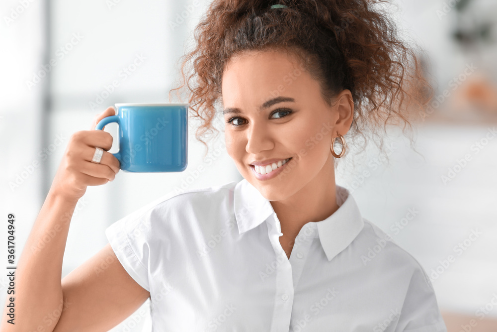 Beautiful young African-American woman drinking hot tea at home Beautiful young African-American woman drinking hot tea at home