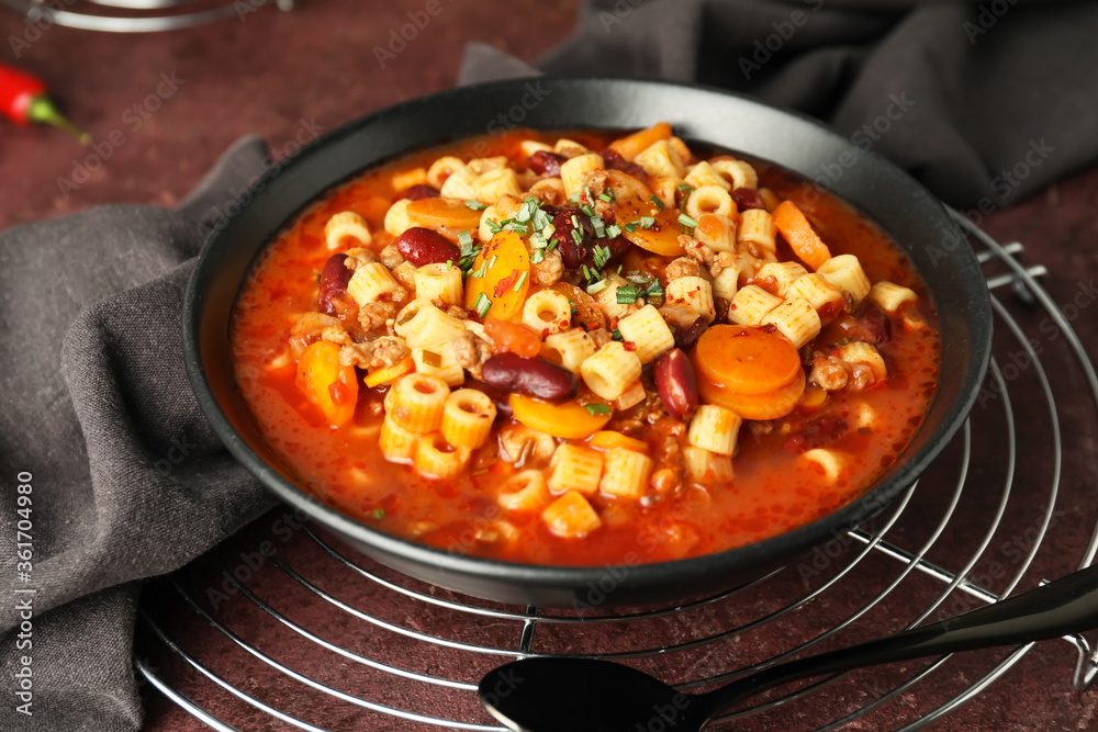 Bowl with tasty pasta and beans on table