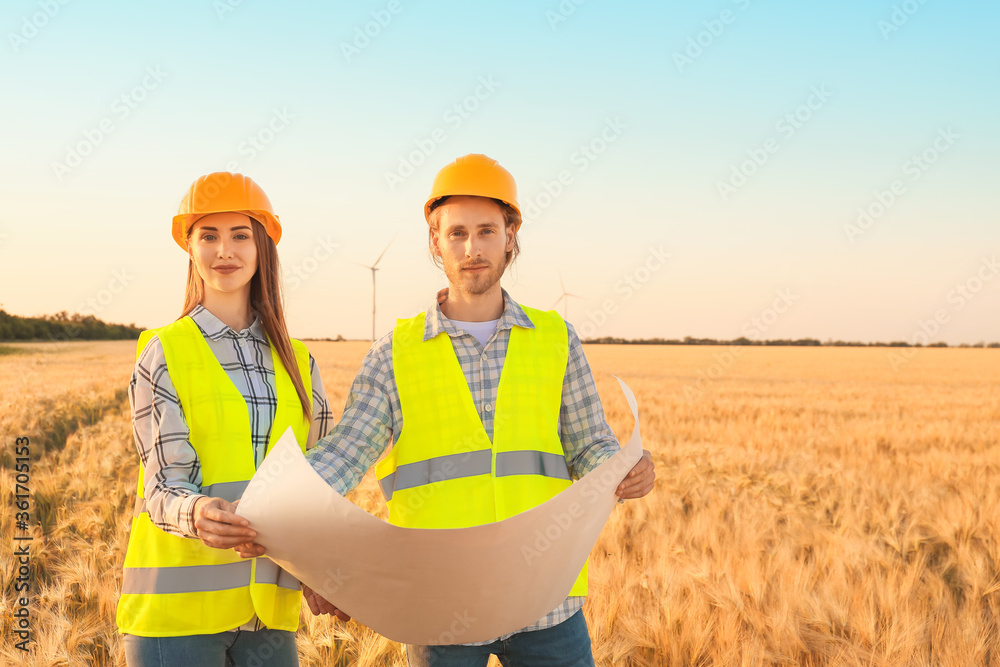 Engineers on windmill farm for electric power production Engineers on windmill farm for electric power production