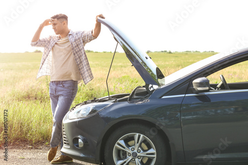 Young man near broken car on road © Pixel-Shot