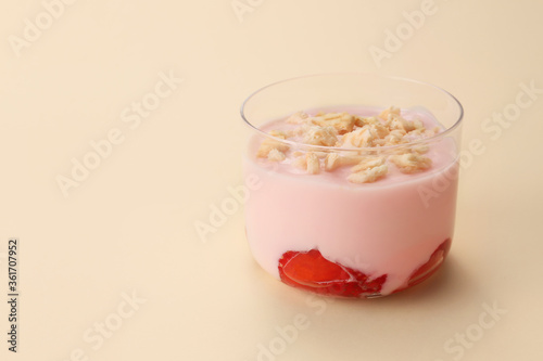 Glass of healthy strawberry yogurt on color background