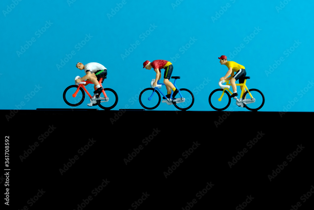 Bike cycling trainer and tracing app. A cycling above smartphone. Miniature people figure conceptual photography. Bike cycling trainer and tracing app. A cycling above smartphone. Miniature people figure conceptual photography.