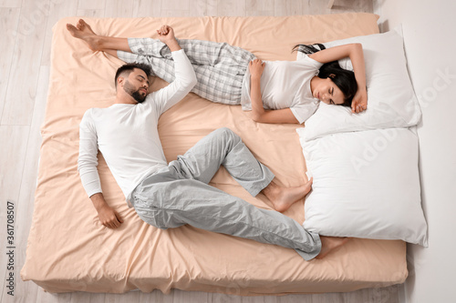Young couple sleeping in be...