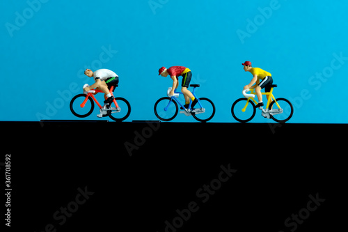 Bike cycling trainer and tracing app. A cycling above smartphone. Miniature people figure conceptual photography.