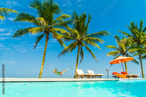 Woman relaxing on a hammock at the swimming pool