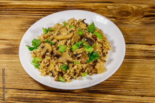 Tasty risotto with mushrooms on wooden table
