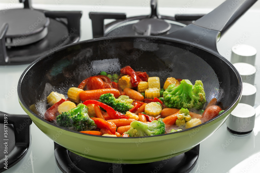 Close-up of frying vegetables in a pan on a gas stove Close-up of frying vegetables in a pan on a gas stove