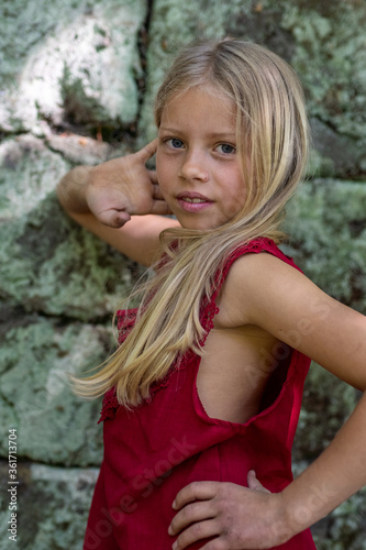 Porträt eines jungen, hübschen, manchmal nachdenklich oder frechen Mädchens in einem schicken roten Kleid.
