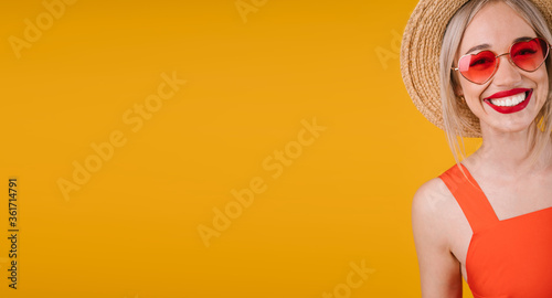 Active Adorable smiling blonde woman portrait on yellow background. Heart shaped fashionable pink sunglasses. Happy summer mood vibes moments. Horizontal long banner. big red lips teeth smile