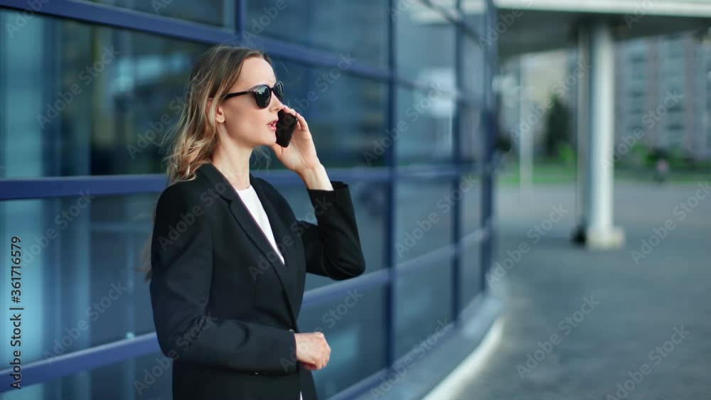 Focused businesswoman use phone discussing work at cityscape. Medium shot on RED camera Focused businesswoman use phone discussing work at cityscape. Medium shot on RED camera