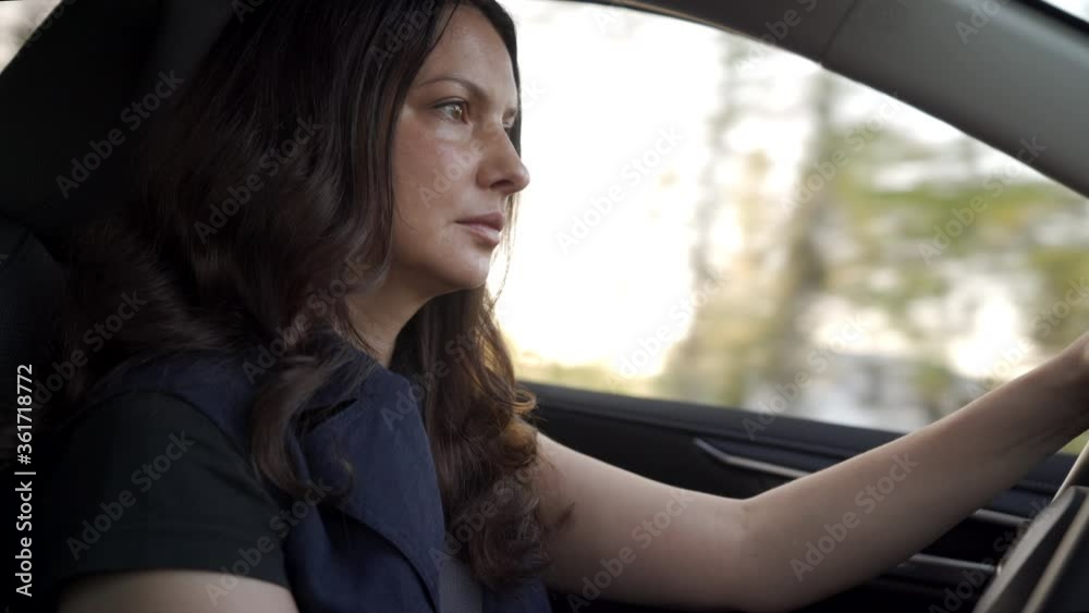 Portrait of beautiful woman driving car while sunset sun rays shine through car window side view of adult woman drives a automobile. Portrait of beautiful woman driving car while sunset sun rays shine through car window side view of adult woman drives a automobile.