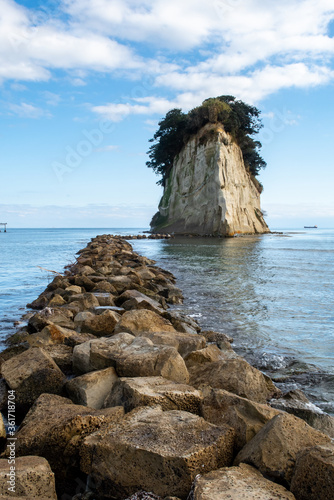 Mitsukejima diamond shaped island with trees on top of the rock, view with stone pier, on Noto Peninsula, Japan photo