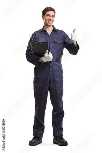 Male worker in a uniform holding a clipboard and showing thumbs up