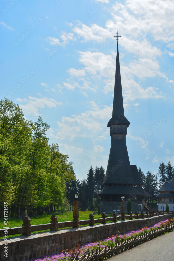 Sapanta Peri Monastery, Maramures, Romania, Europe, spring 2018. Traditional wooden church with the tallest bell tower in the world. Maximum height of 78 meters. Surrounded by vegetation.