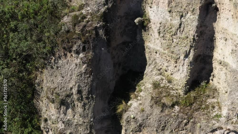 Moving up and sidewards to show a large cliff and the surrounding environment in the andean mountains
Moving up and sidewards to show a large cliff and the surrounding environment in the andean mountains