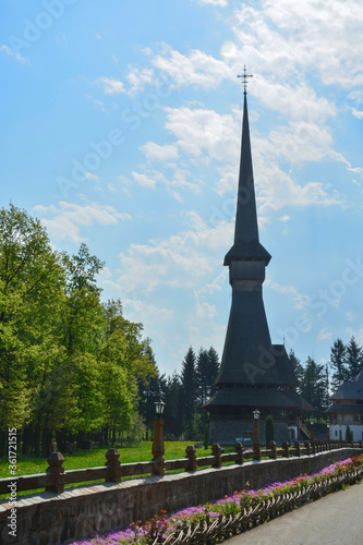 Obraz na płótnie Sapanta Peri Monastery, Maramures, Romania, Europe, spring 2018. Traditional wooden church with the tallest bell tower in the world. Maximum height of 78 meters. Surrounded by vegetation. w salonie