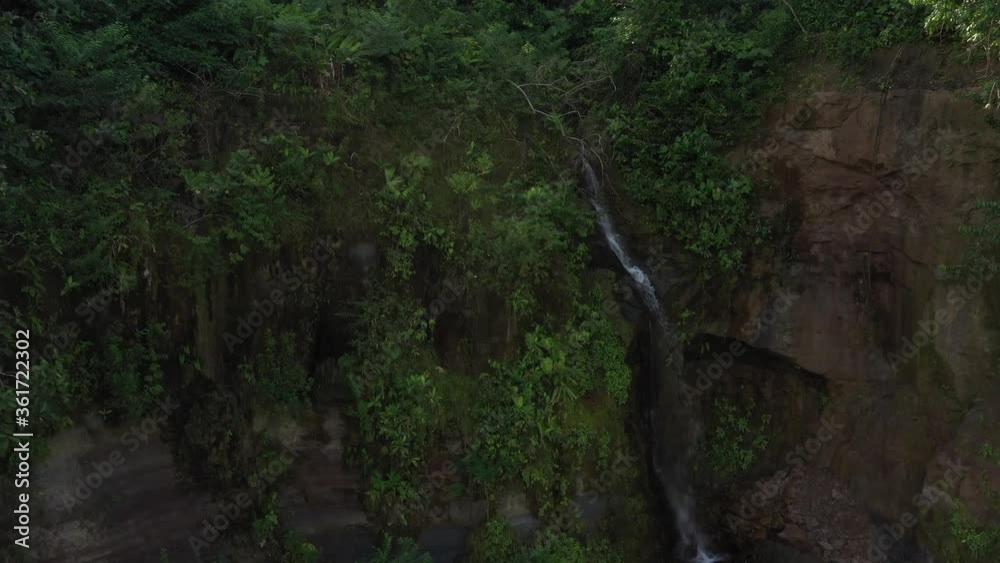Aerial view, slowly flying to a cascade in the tropics with sunbeams coming in from behind the waterfall
Aerial view, slowly flying to a cascade in the tropics with sunbeams coming in from behind the waterfall