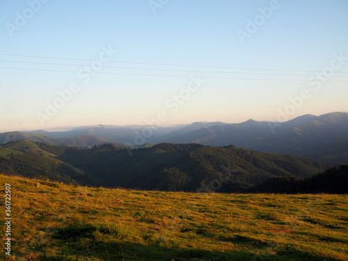 Pradera con montañas al fondo al atardecer.