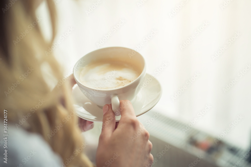 Young girl holding a cup of freshly brewed white coffee. Young girl holding a cup of freshly brewed white coffee.
