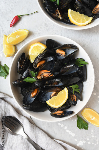 Delicious seafood mussels with lemon and parsley dish on grey background. the view from the top. flat Ley food recipe