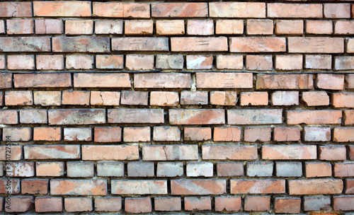 texture of old brick wall without mortar in gaps between bricks.