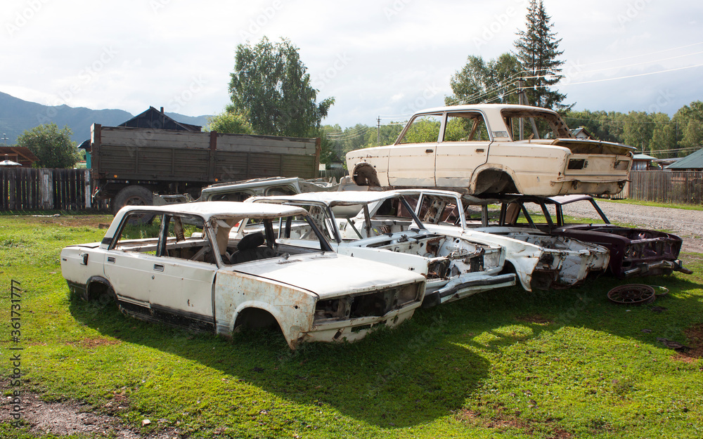 Car cemetery. Old broken cases of Russian cars lie on the ground Car cemetery. Old broken cases of Russian cars lie on the ground