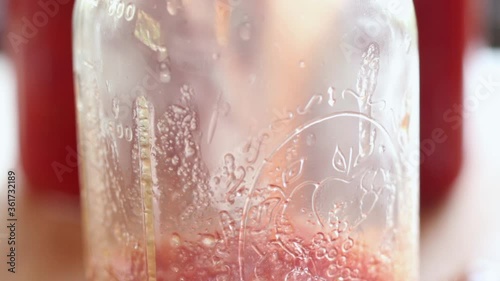 Pouring hot stewed tomatoes into a jar