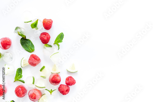 Berries and mint in ice cubes top view frame copy space