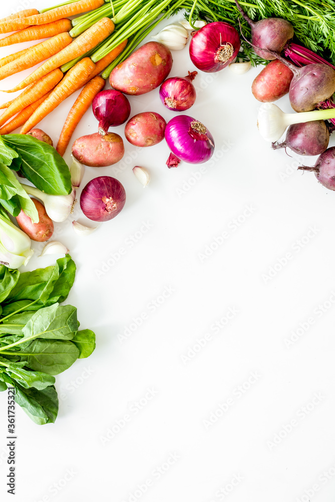 Vegetables harvest with green tops on white table top view frame copy space Vegetables harvest with green tops on white table top view frame copy space