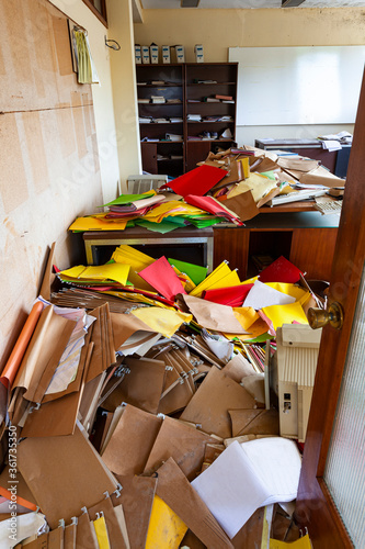 oficina totalmente desordenada y con todo el material de oficina tirado por el suelo ó oficina desordenada después de un crisis financiera