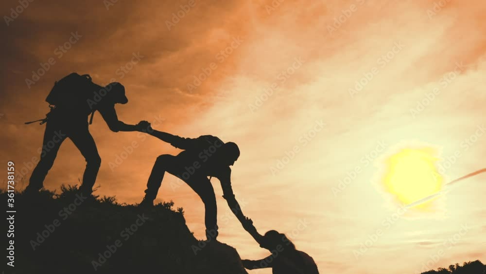 teamwork help business travel silhouette concept. group team of tourists lends a helping hand climb the cliffs mountains lifestyle. teamwork people climbers climb to top lifestyle overcoming hardships