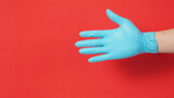 Hand fit with natural latex gloves or surgical glove on red background..