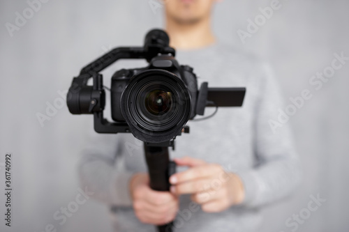 Εκτύπωση καμβά close up of modern dslr camera on 3-axis gimbal stabilizer in male videographer