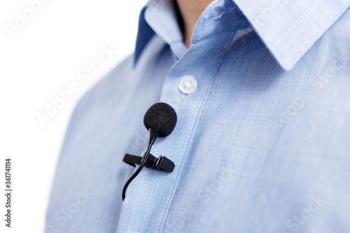 Photos sound recording concept - close up of small lavalier clip-on microphone on male