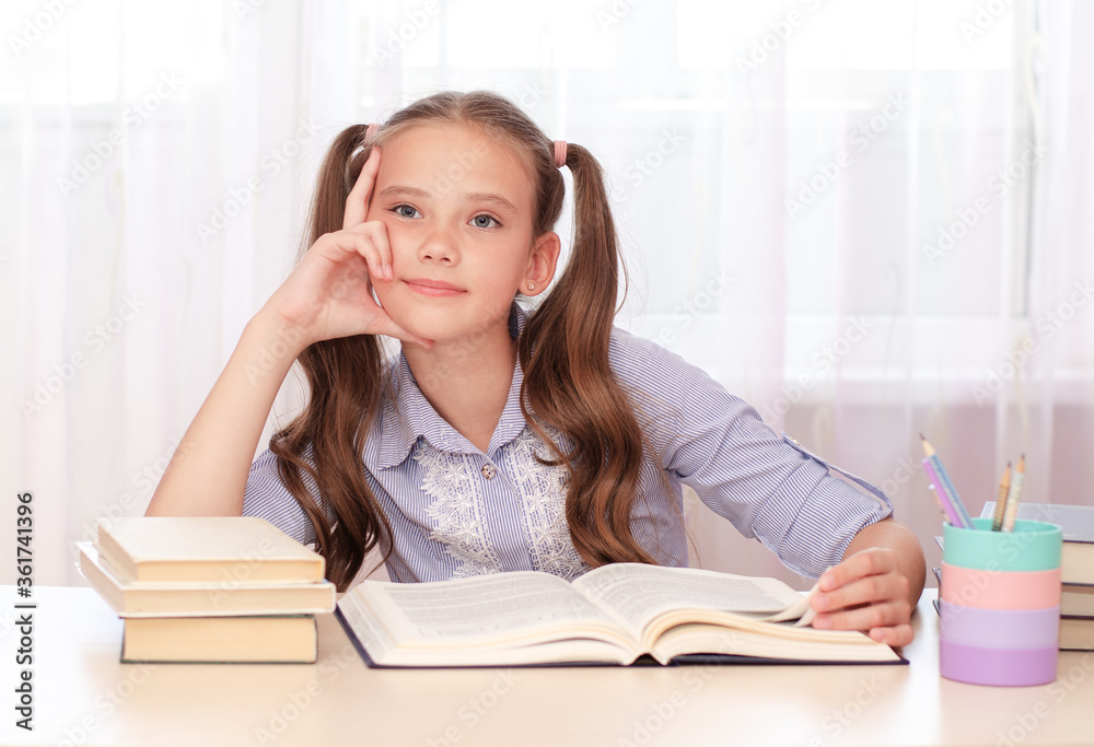 Education and school concept. Cute child is sitting at the desk and thinking Education and school concept. Cute child is sitting at the desk and thinking