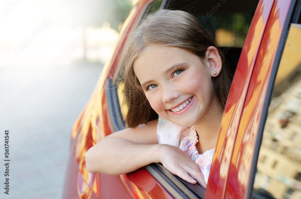 Happy cute little girl child looks out the window of the car Stock ...