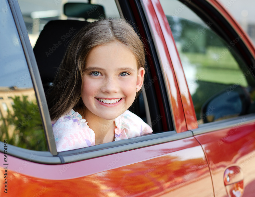 Happy cute little girl child looks out the window of the car Stock ...