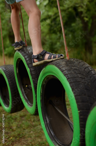 the child’s legs walk on the tires. Sports and recreation in a sports park. photo