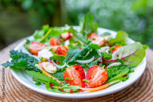 A healthy and delicious salad made from fresh strawberries and vegetable leaves. Vegetarian food.