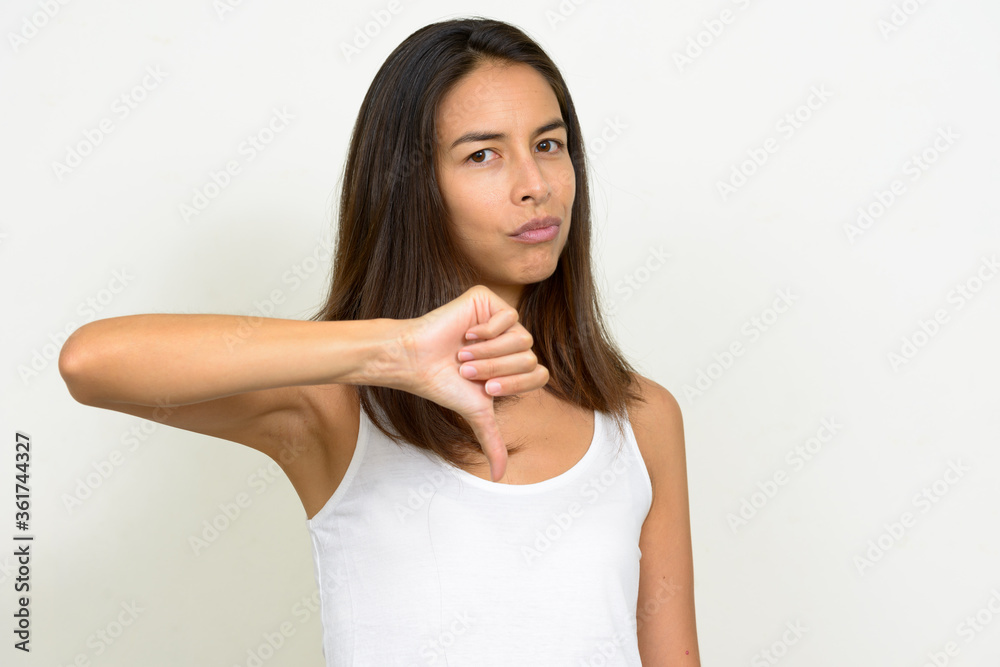 Portrait of stressed multi ethnic woman giving thumbs down Portrait of stressed multi ethnic woman giving thumbs down