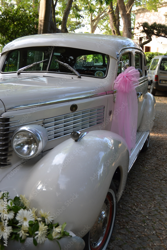 A classic car decorated as a bridal car.