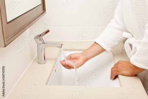 man washing hands in bathroom