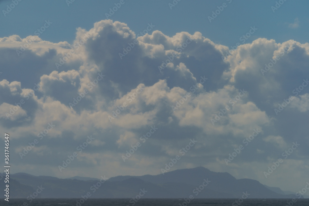 Beautiful cloudscape over the Atlantic ocean in hot summer day. Breathtaking seascape in Zumaia in Basque Autonomous Community / country in summer cloudy day. Biscay Bay. High resolution photography