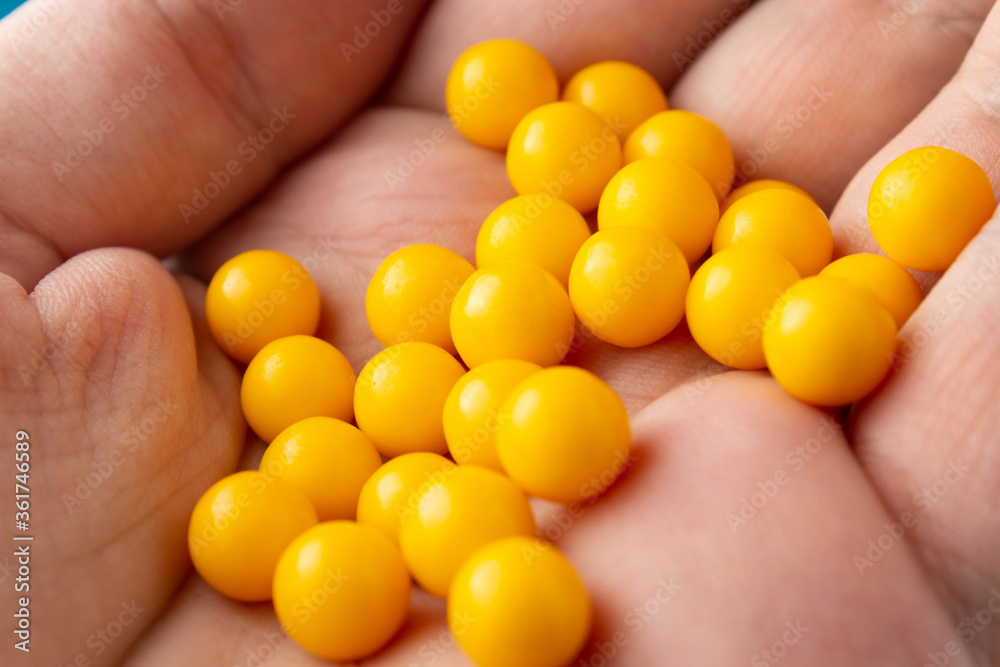 Yellow round pills on palm close up Yellow round pills on palm close up