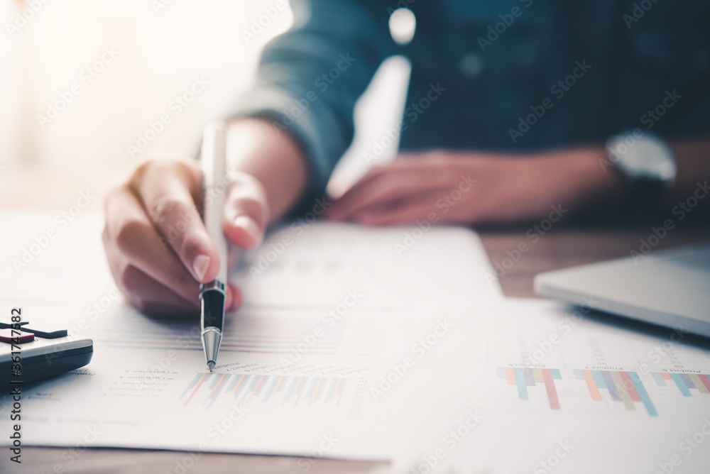 businessman pointing with pen on business report chart are working on accounts in business analysis with graphs and documentation. businessman pointing with pen on business report chart are working on accounts in business analysis with graphs and documentation.