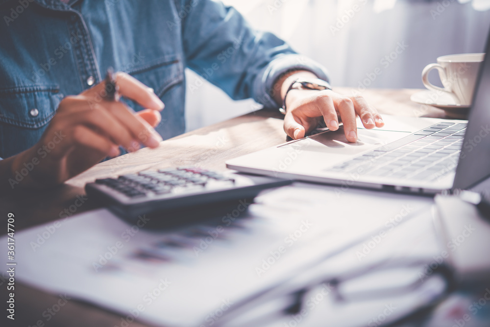 business person sitting at a desk at an office By using the calculator to work. Business Concept Analysis and Planning business person sitting at a desk at an office By using the calculator to work. Business Concept Analysis and Planning