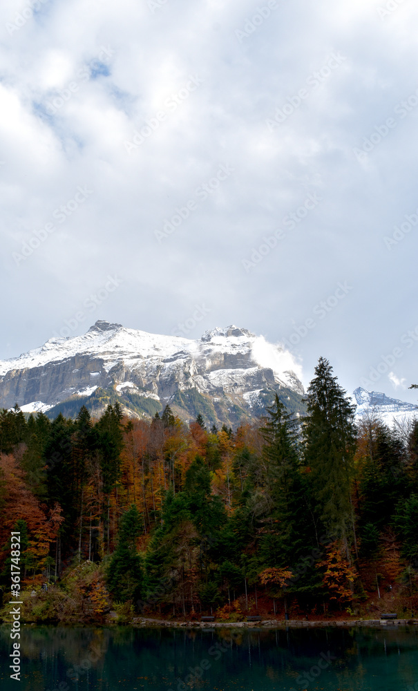 Blausee, Kandergrund, Switzerland - 11.01.2018: Beautiful mountain blue lake in the mountains. Autumn landscape, yellow trees. Crystal clear, transparent water of the blue lake. Mountain landscape.