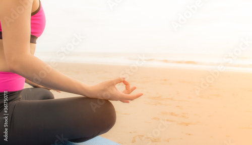 Young woman practicing yoga outdoor on the beach in morning