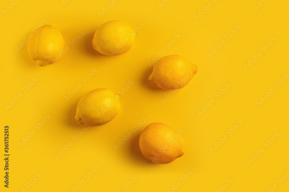 Five ripe lemons on a yellow background in the style of flat lay. Five ripe lemons on a yellow background in the style of flat lay.