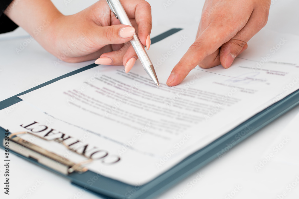 Close-up of hands signing contract agreement Close-up of hands signing contract agreement